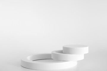 White podium on the white background, simple geometric forms. Podium for product, cosmetic presentation. Creative mock up. Pedestal or platform for beauty products.