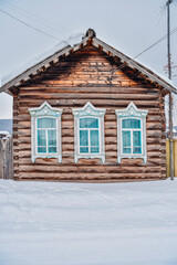 Russian village in winter. Siberia, Taiga. Wooden houses under the snow. Cold Russian winter
