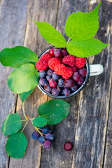 there are different and tasty berries in a white mug. High quality photo