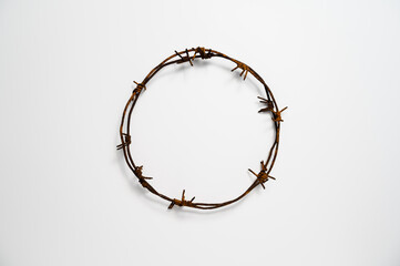 Contemporary Crown of Thorns or Good Friday concept: A wreath of rusted barbed wire against white...