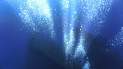 Underwater photo of a spooky and scary wreck on the bottom of the deep blue ocean. From a scuba...