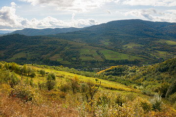 Naklejka premium rural landscape in mountains. cloudy autumn weather. village in the distant valley