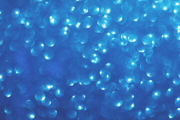 Defocused christmas or party, blue glitter background with bokeh. Holiday glowing backdrop,banner or card.