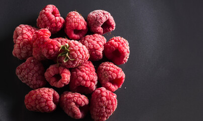 Frozen raspberries on a dark background. Close up. Top view. High definition product. Copy space
