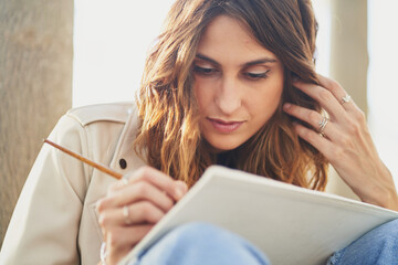 Focused ethnic woman drawing picture on paper