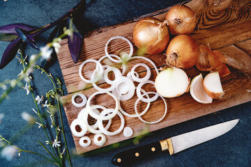 Cebollas y rodajas doradas sobre tabla de cortar de madera.Fondo de comida sana. Un montón de...