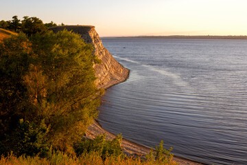 Dawn on the Volga. Beautiful cliffs by the river in the morning rays of the rising sun at golden...