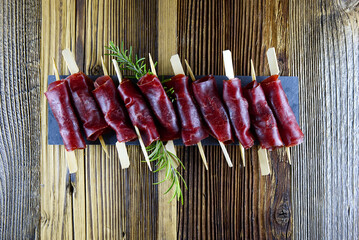 Top view of aperitif from dried meat on wooden background