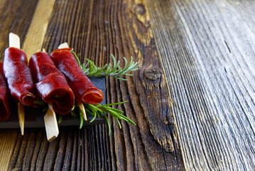 Close up on fresh dried meat appetizer on a wooden background with copy space