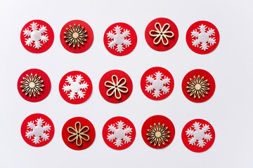 pattern with white fabric snowflake and wooden flower shapes on red paper circles