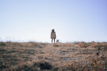 Obraz premium Women standing at a field with a dog
