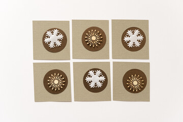 white fabric snowflake and wooden starburst shapes on paper circles and squares