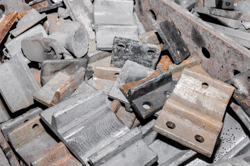 Iron parts of the workpiece for laying railway tracks metal structures in a heap at an industrial plant