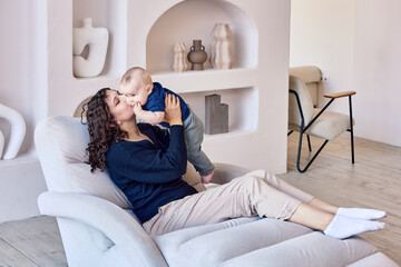 Obraz premium Woman spends time with infant on sofa in living room.