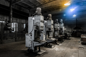 Obraz na płótnie Canvas Old vertical milling machines equipment with flanged electric motors for metal processing in the workshop of the industrial plant