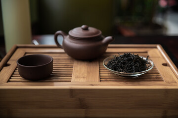 Beautiful indoor scene with Chinese tea items as tea pot, tea glass and black tea on traditional indoor environment