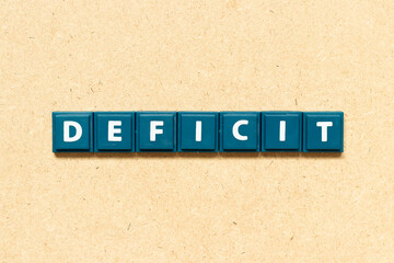 Tile alphabet letter in word deficit on wood background