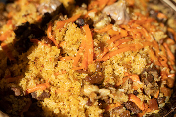 Rice with carrots and garlic. National dish of Uzbekistan. A delicious meal outside.