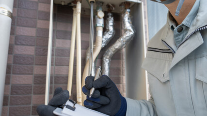 ガス給湯器の点検をする作業員。