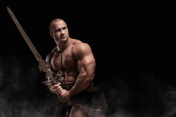 Ferocious muscular ancient warrior barbarian with fantasy sword on black background - 466227567