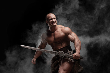 Ferocious muscular ancient warrior barbarian with fantasy sword on black background