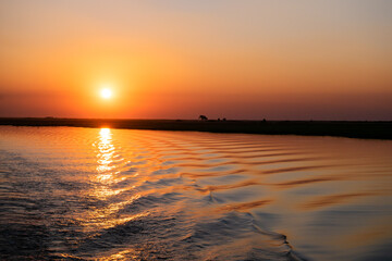 Obraz premium チョベリバークルーズからの夕陽と川面のさざ波