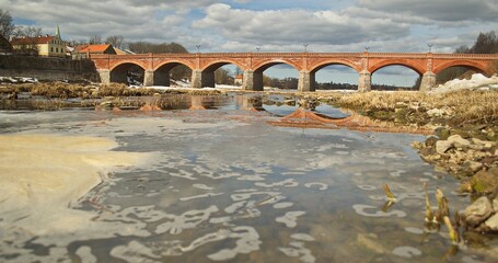 Long red brick bridge in sunny spring day, Kuldiga, Latvia.