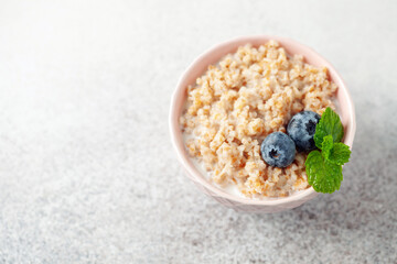 Wheat porridge with berries in a ceramic bowl. Healthy breakfast