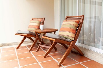 Brown wooden chairs and brown cushions on the balcony