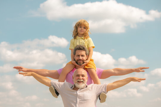 Grandfather with son and grandson raising hands or open arms flying. Multi Generation Family. Fathers day.