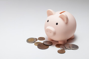 a piggy bank with a pile of coins on white background.