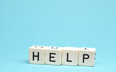 Wooden blocks with the word help on a blue background