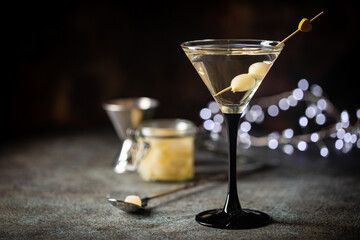 Gibson alcohol cocktail with martini and onions in martini glass. Decorated cocktail on dark background