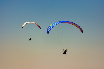 Two paragliders gliding away.