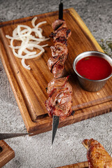 Fototapeta premium Grilled lamb shashlik with red sauce and onion