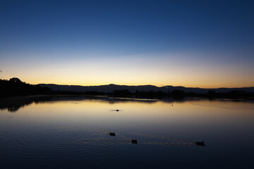 水辺に映る夜明けの表情