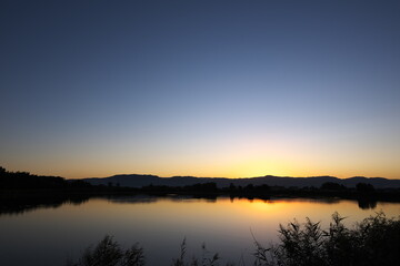 水辺に映る夜明けの表情