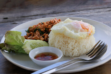 Rice with pork stir fried with basil and fried egg on black background, Thai food, Street food