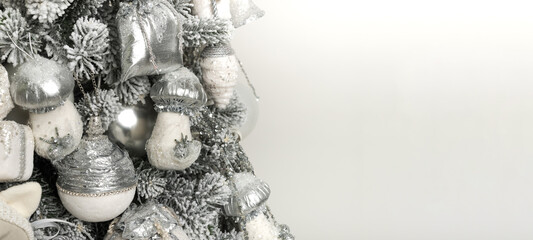 Isolated gray-white Christmas tree with toys and garlands on white background