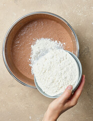 add flour to the bowl of chocolate cake dough