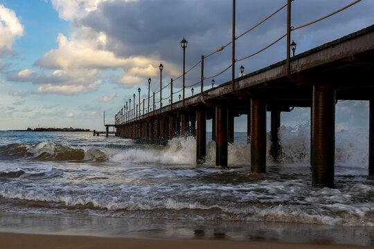 Sea waves crash on pier piles