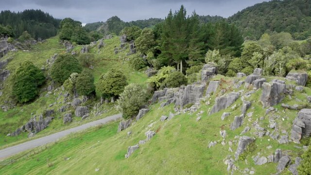Aerial: Limestone outcrops and rugged farm landscape. Location used in the Lord of the Rings movie.  Waitanguru, Waikato, New Zealand