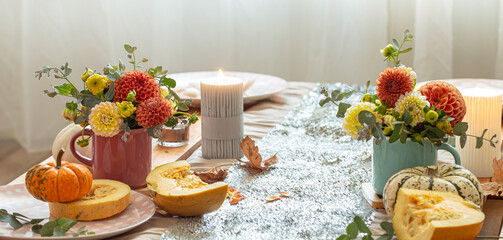 Festive table setting with pumpkins and chrysanthemum flowers.