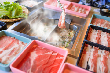 hot pot meal. Hands taking food with chopsticks.