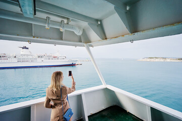 Voyage or cruise. Young woman enjoying view on ship deck. Sailing the sea.
