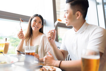 Happy young couple having fun during lunch in restaurant