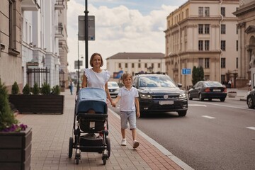 Mother and two kids walking in city center