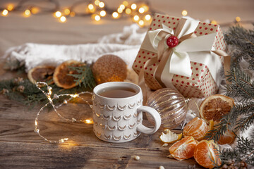 Christmas composition with a festive cup and tangerines on a blurred background.