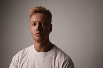 Obraz premium Portrait of a handsome young man posing against white wall. Space for text.