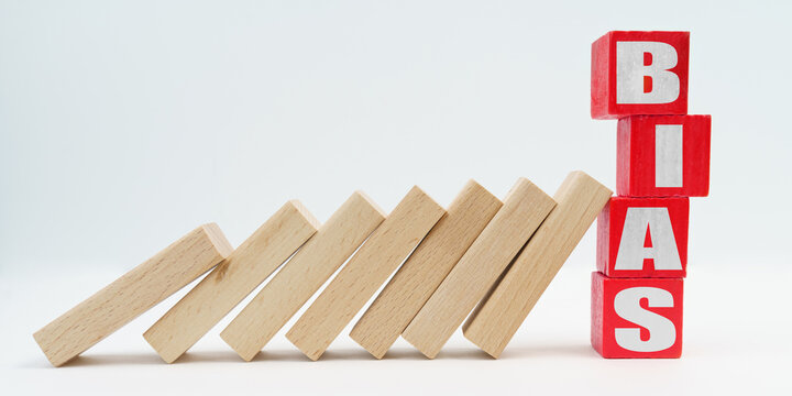 On a white background, wooden dice fell like dominoes, the fall was stopped by cubes with the inscription - BIAS